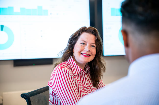 Lady smiling in front of a screen