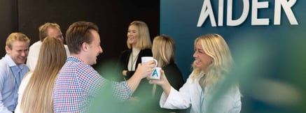 Personer drikker kaffe og smiler