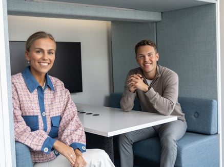 To personer sitter i en bås