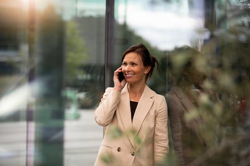 Person i telefonen ved en glassvegg