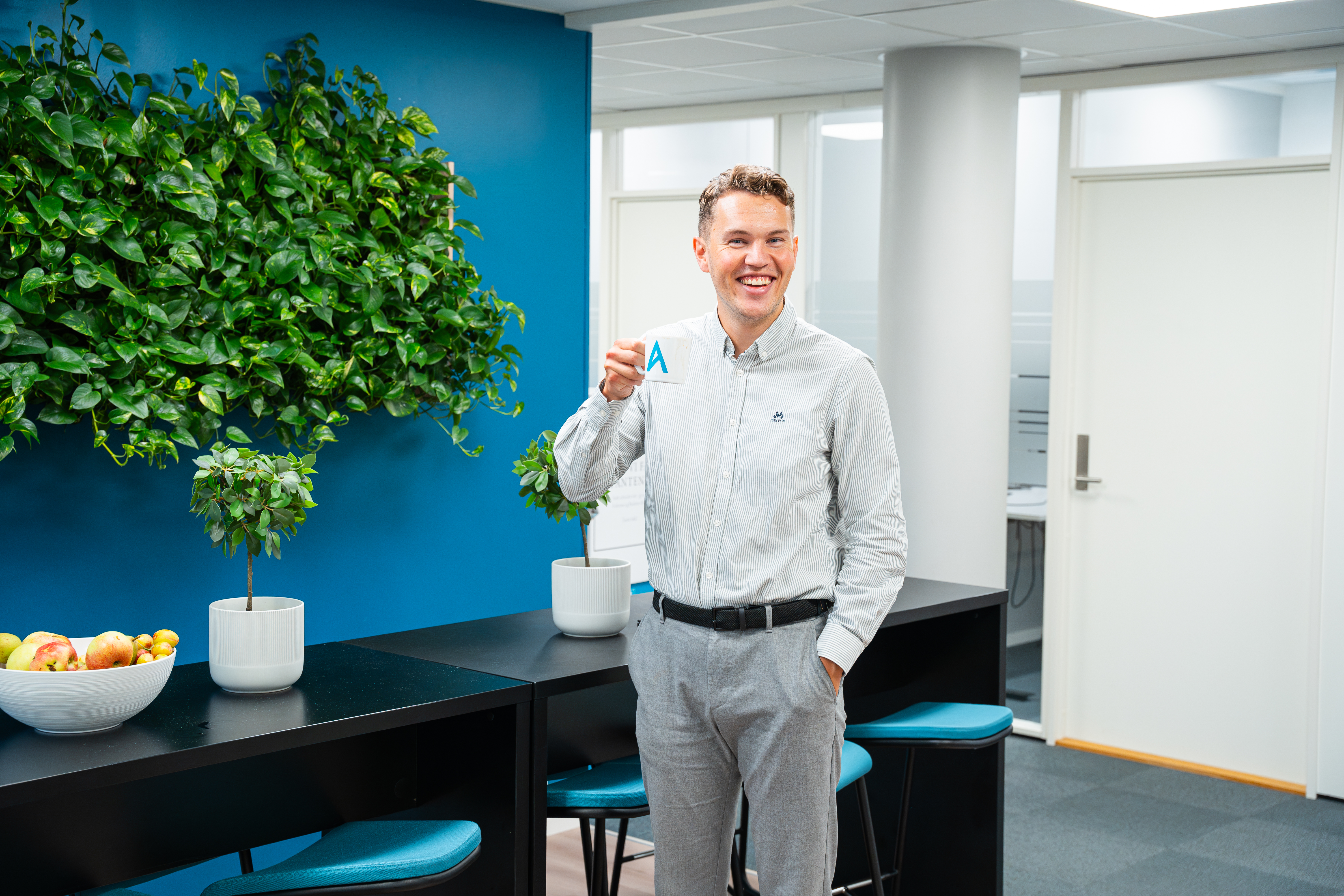 mann som smiler med kopp i hånda