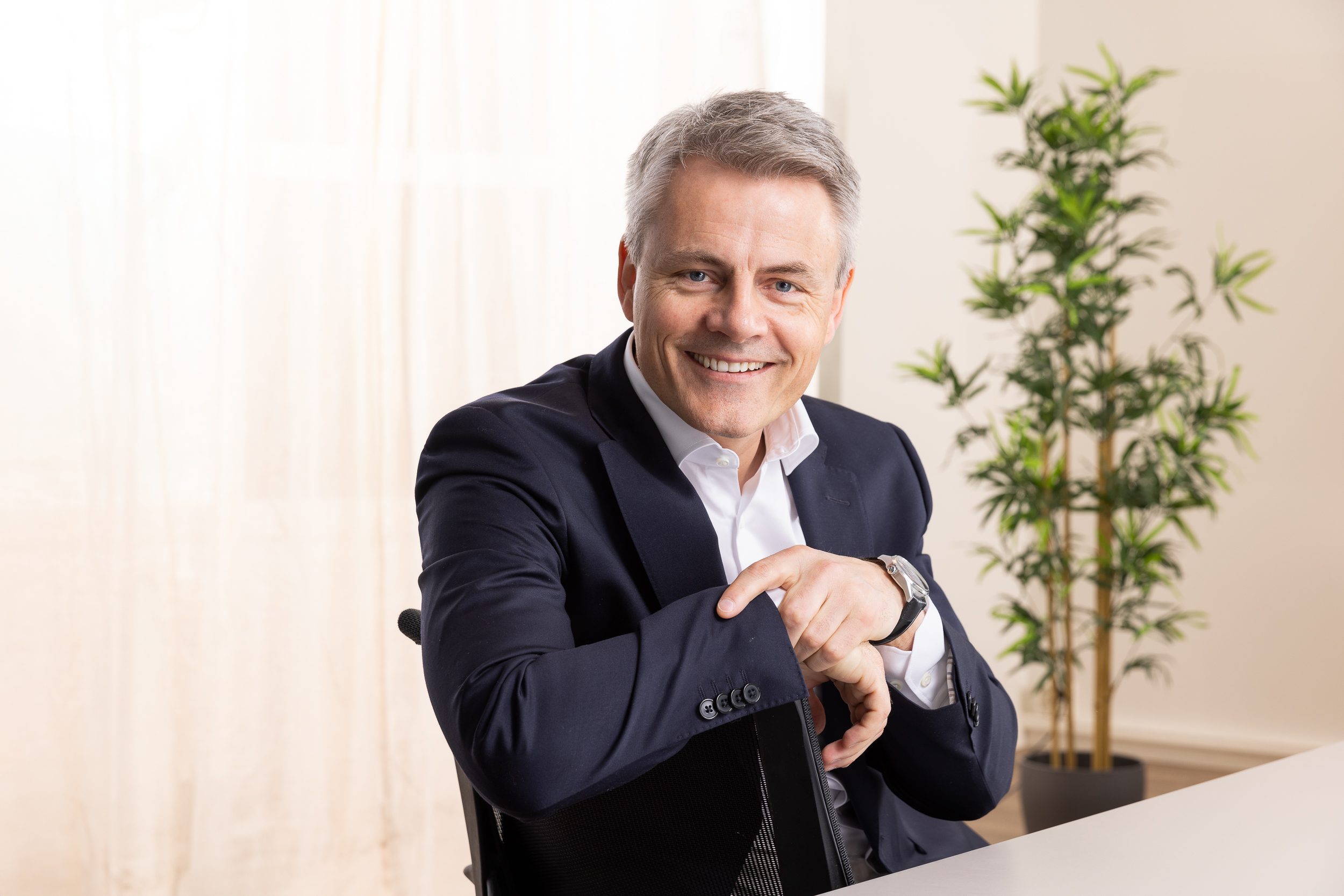 Mann smiler på en stol