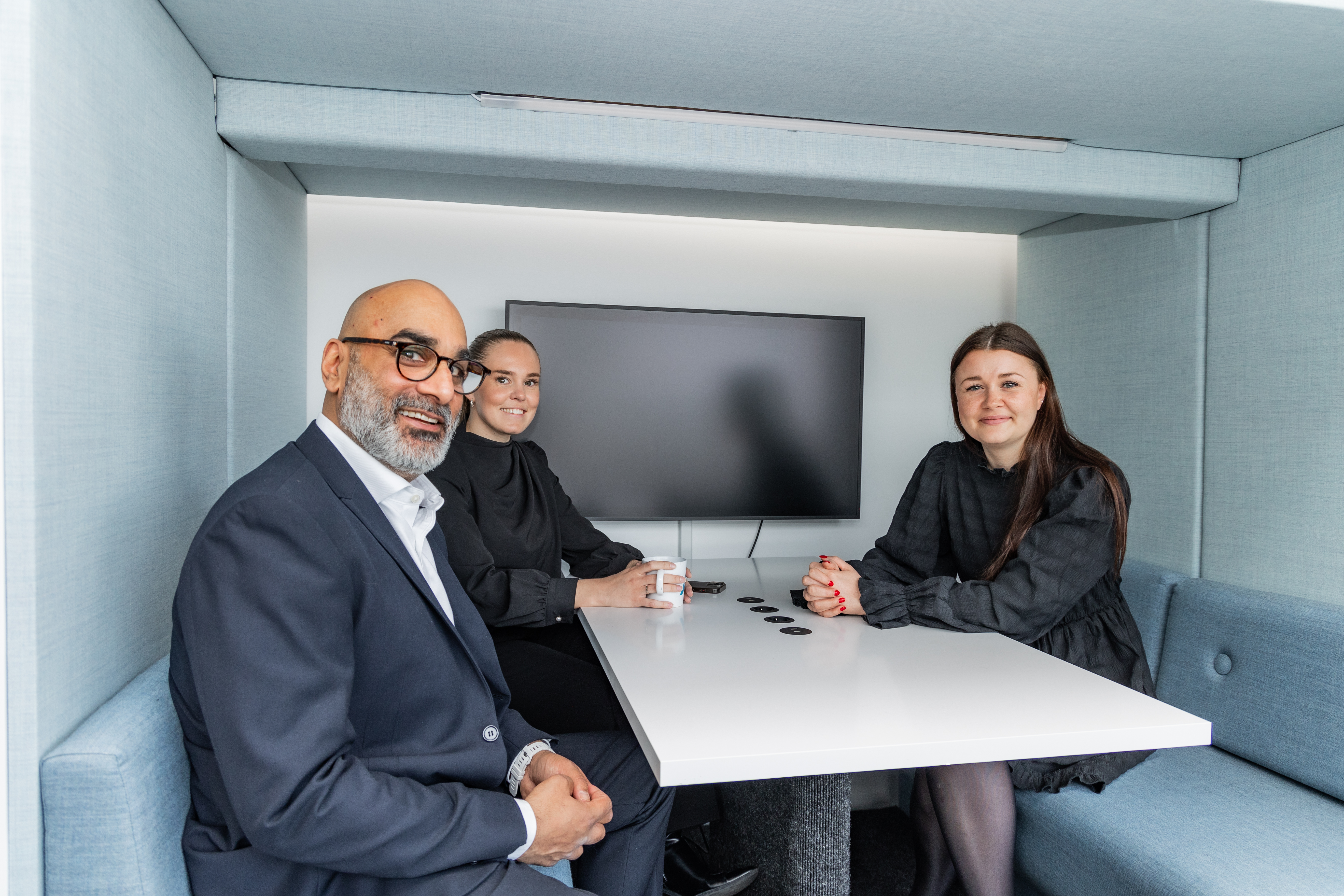 Tre personer smiler til kamera