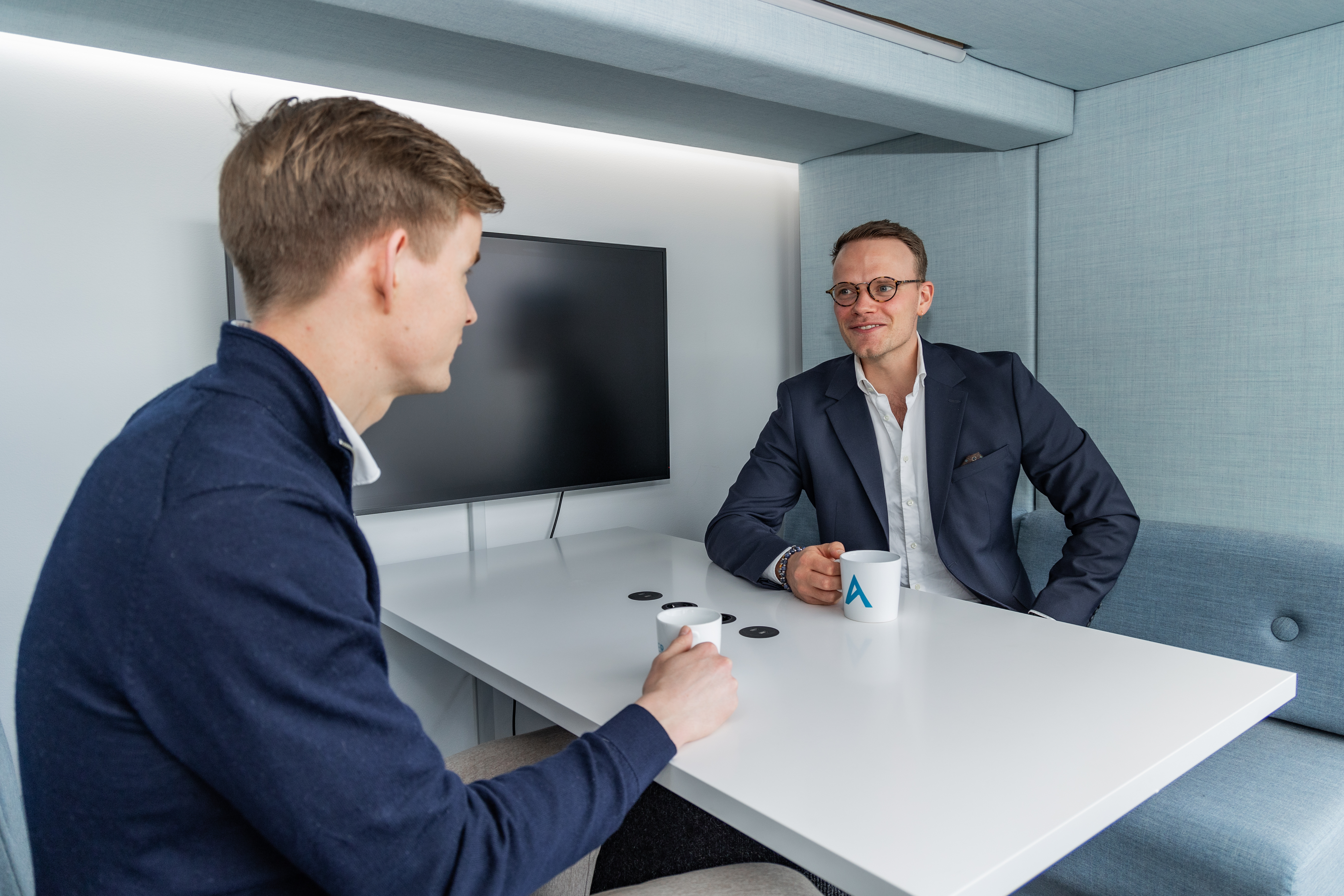 To personer sitter i en bås
