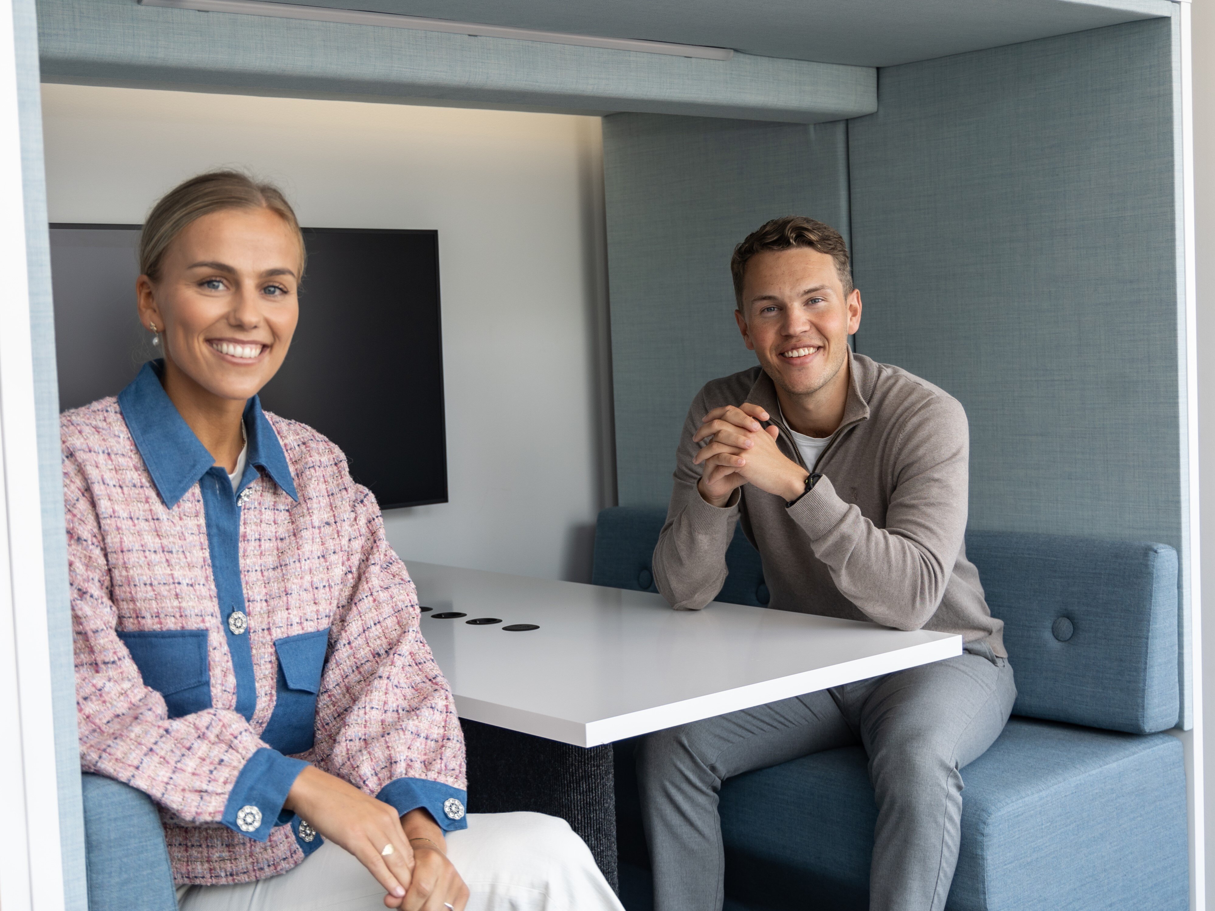 To personer sitter i en bås