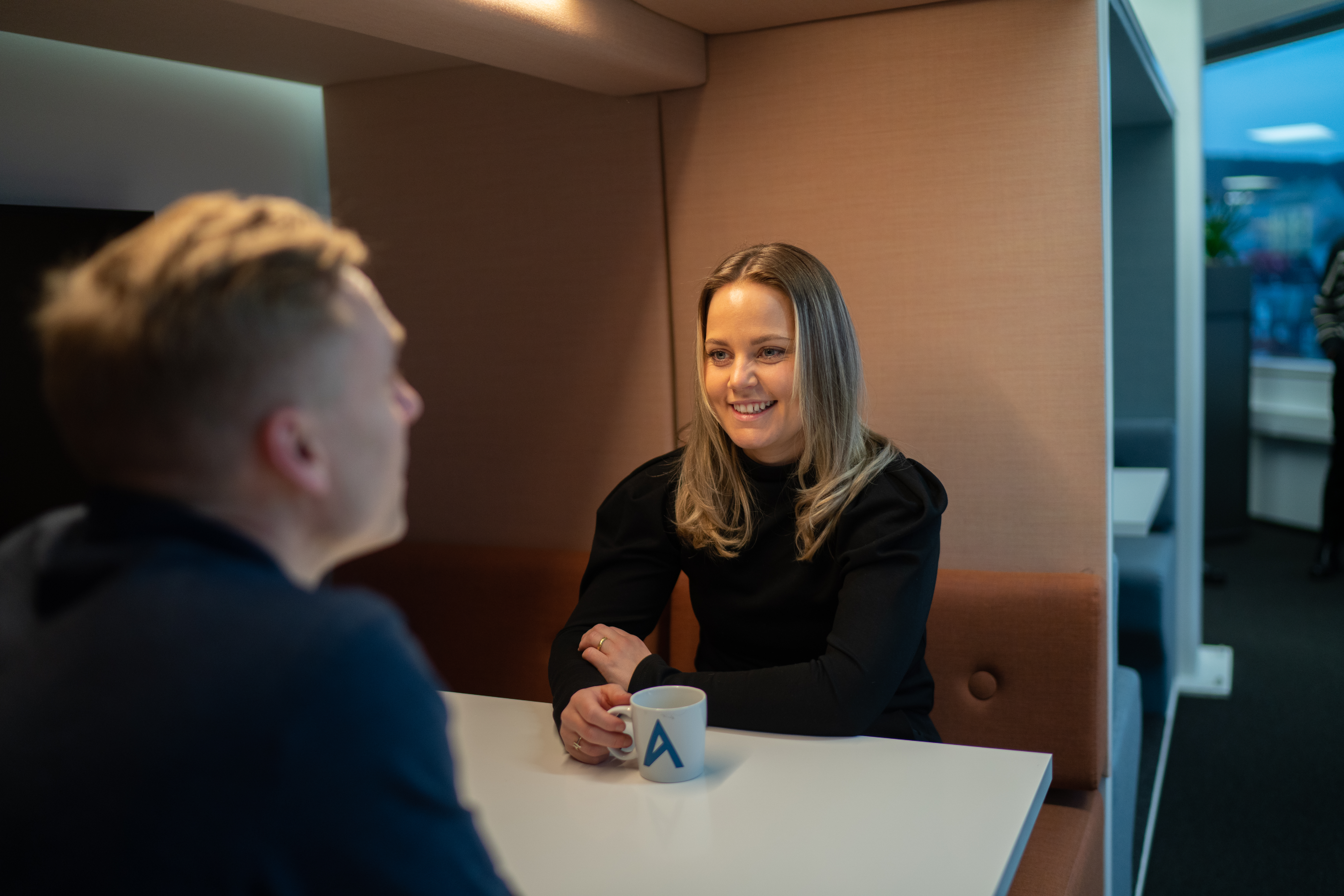 To personer sitter i en bås