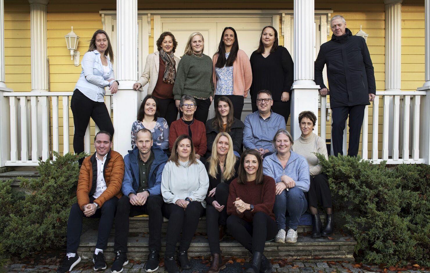 Gruppebilde av mange mennesker som smiler