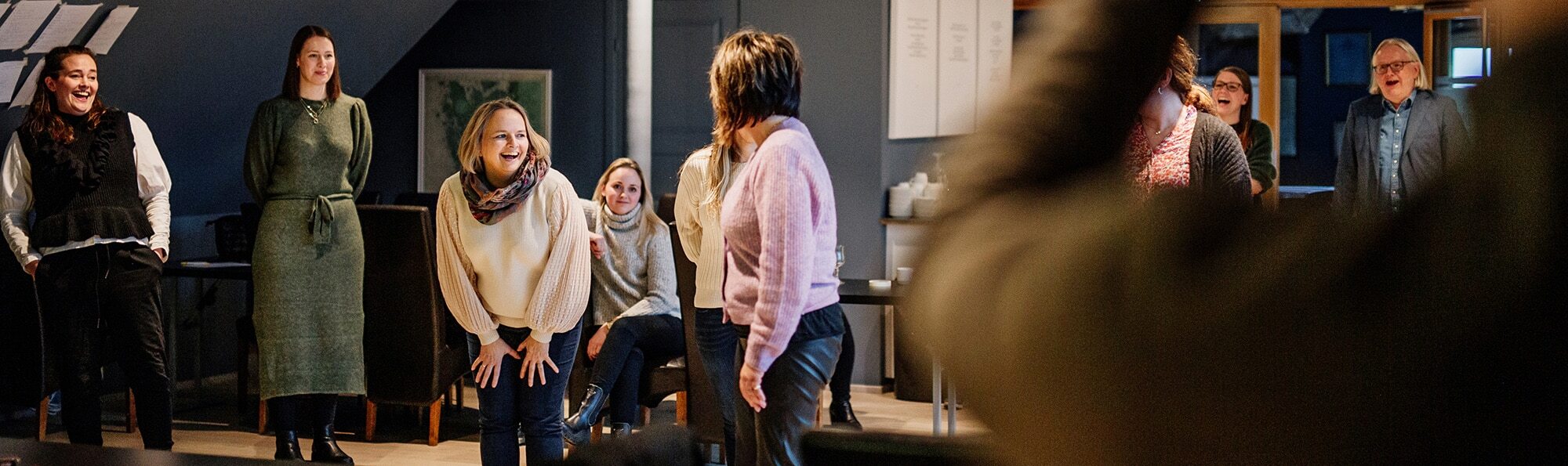 mennesker som ler inne på kontoret