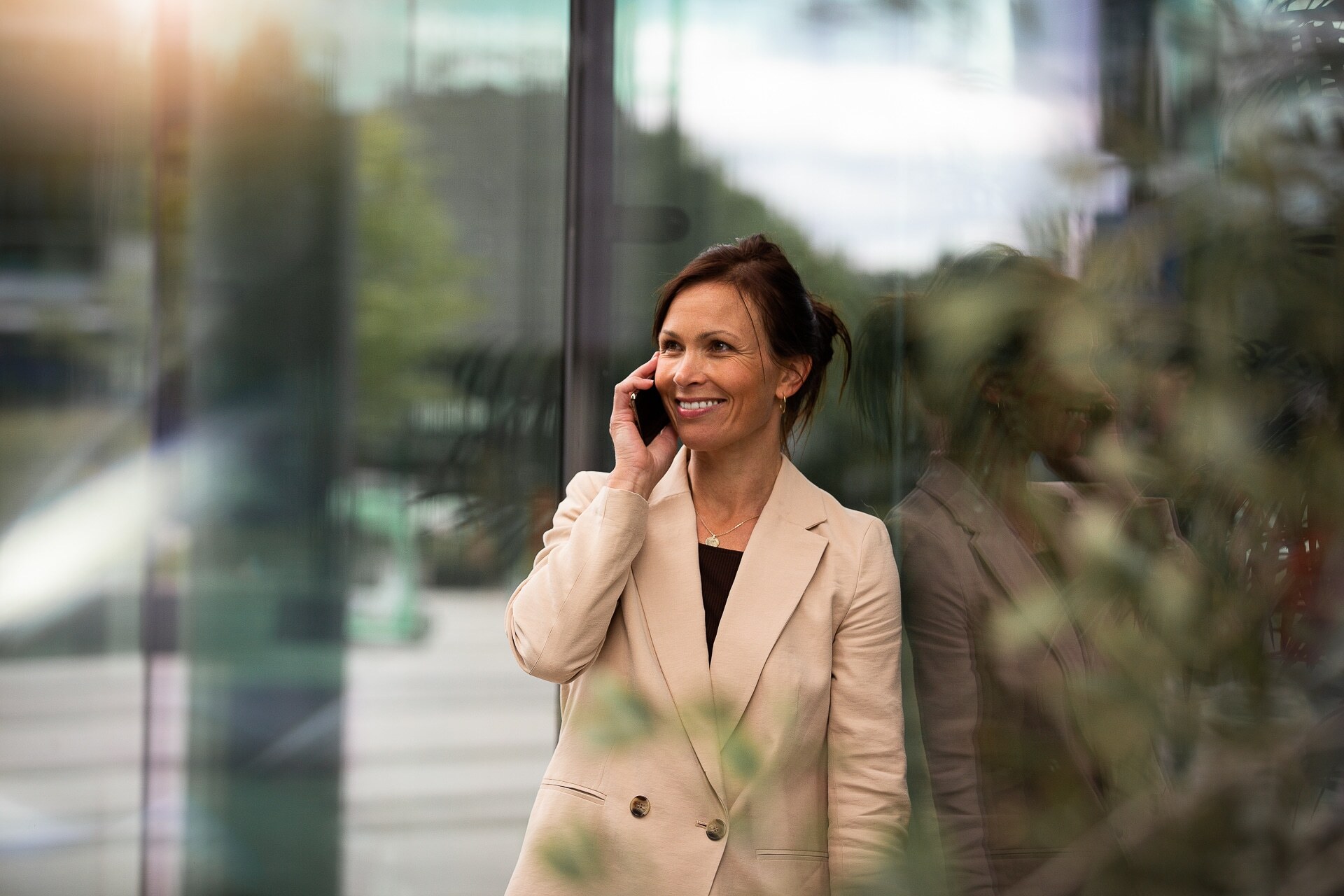 Person i telefonen ved en glassvegg